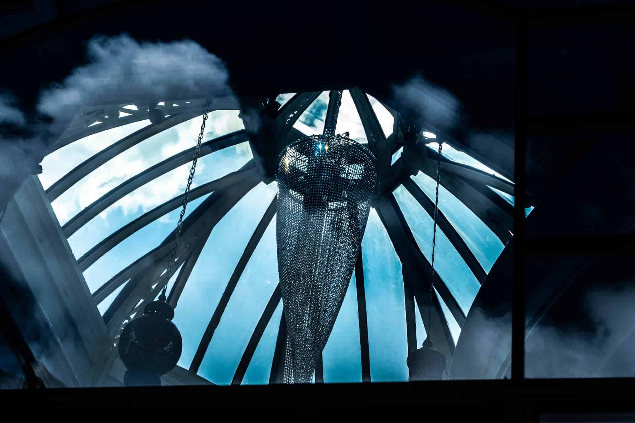 Crystal chandelier behind glass with diffuse clouds