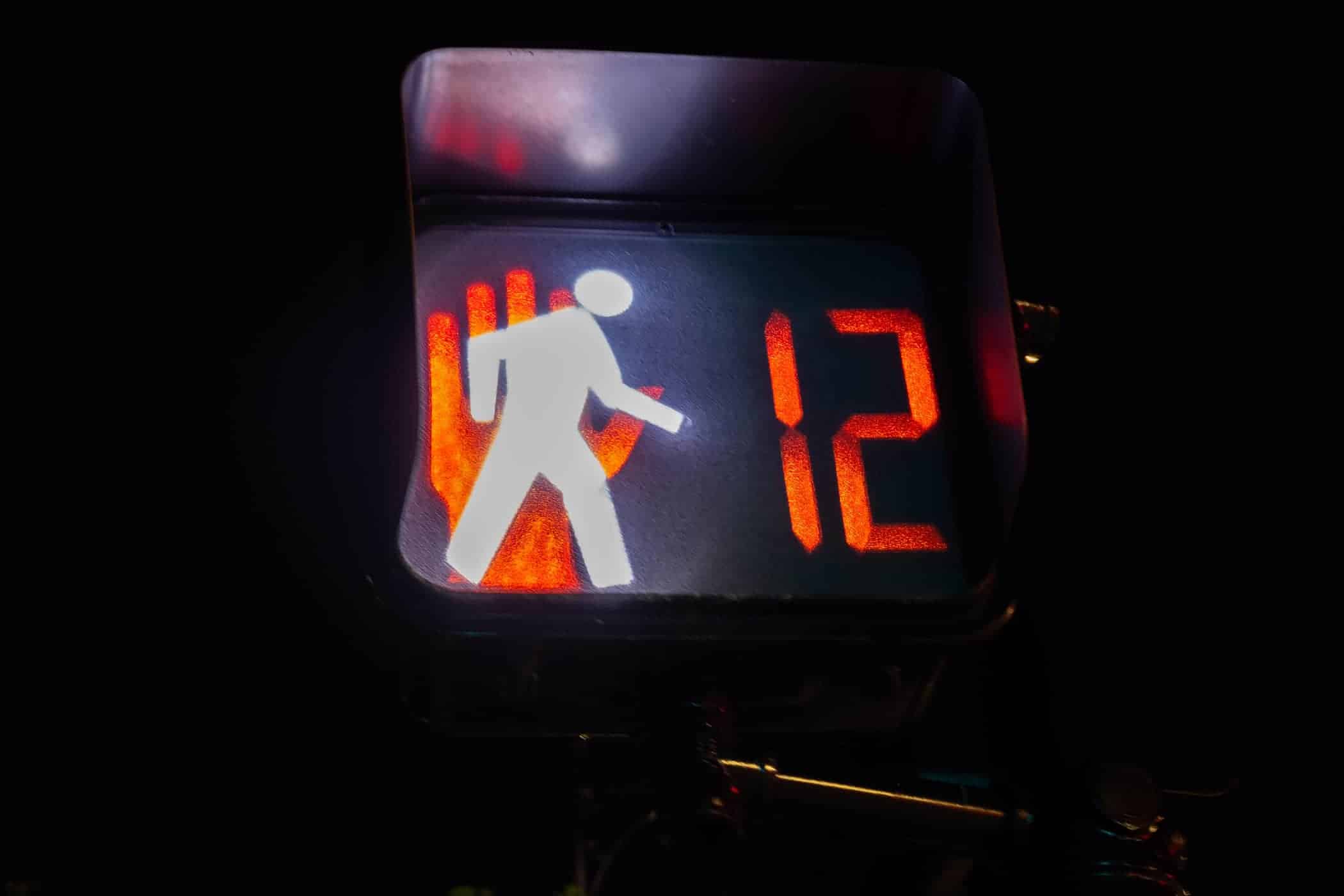 Pedestrian walk sign caught between walk and stop